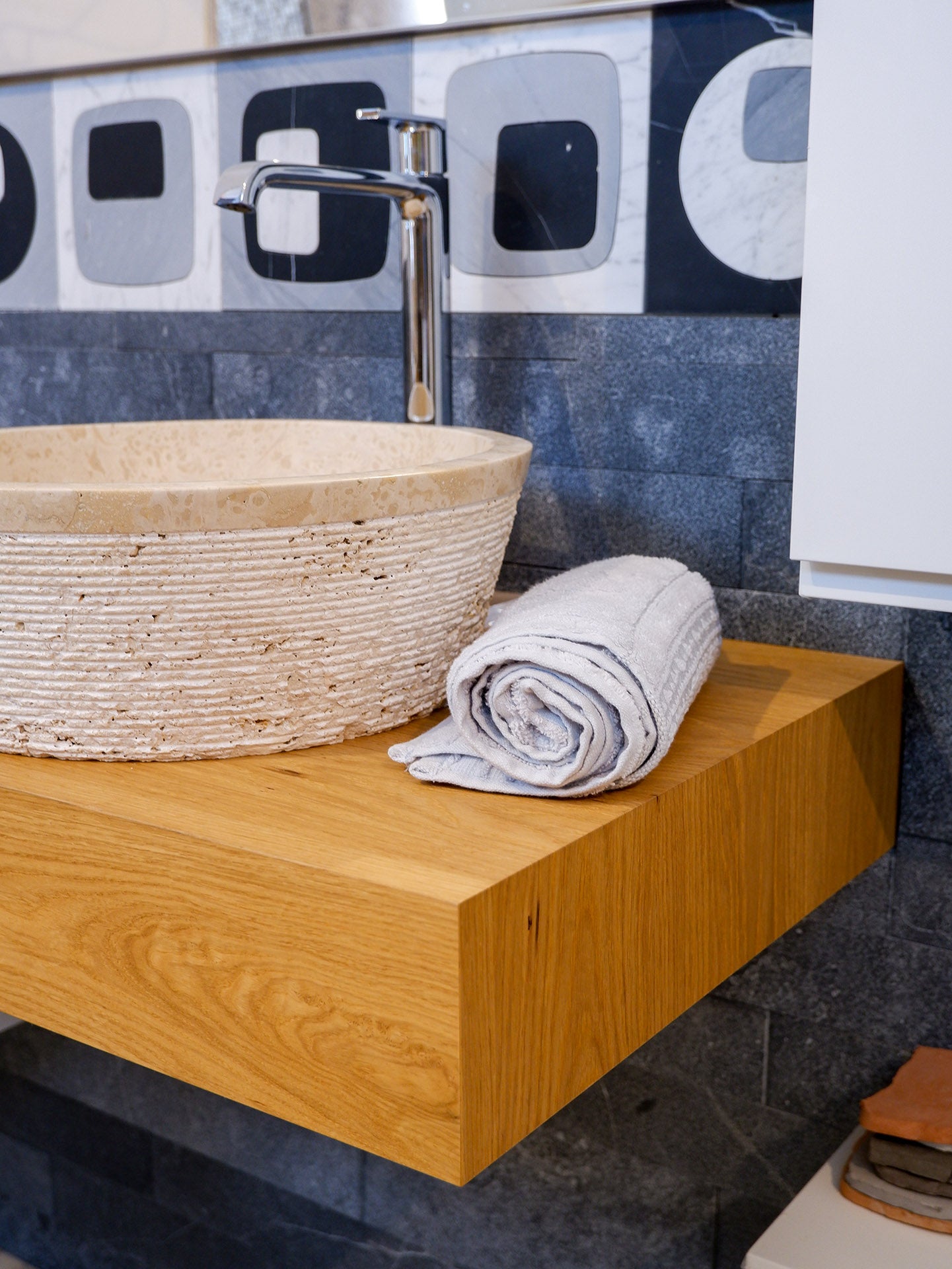 dettaglio del bagno moderno con lavabo travertino chiaro e top in nobilitato di stone art